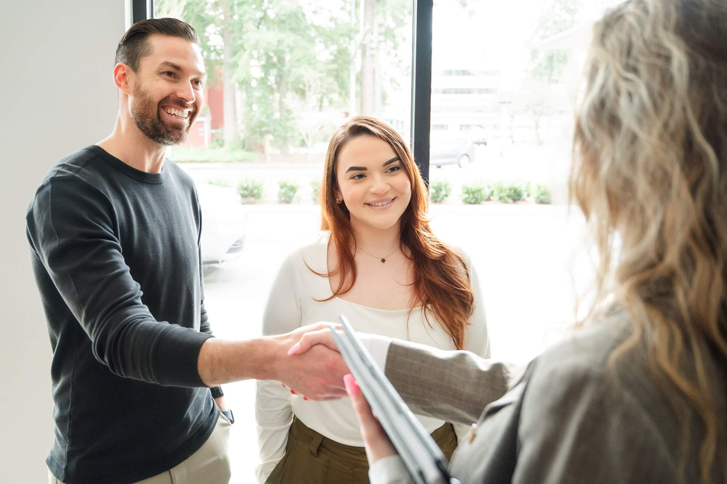 a man and a woman shaking hands with an agent