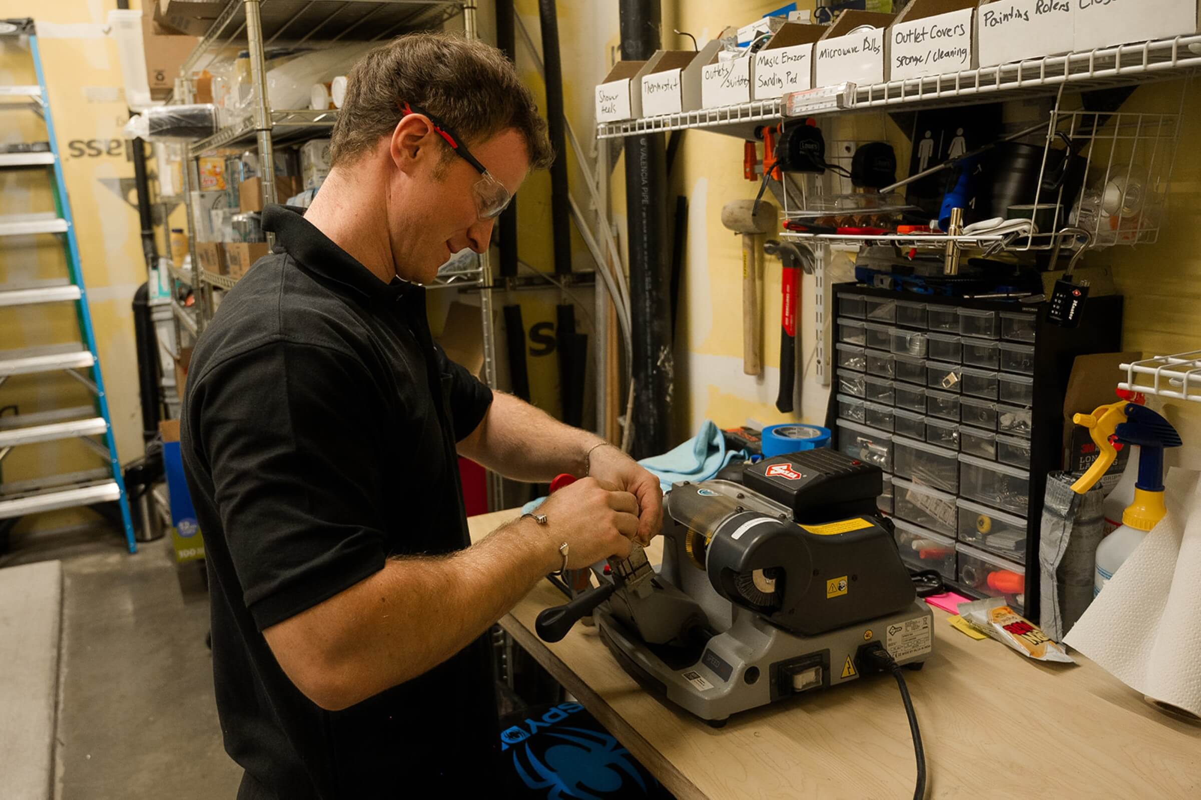 a man working using a table-top machine in a workshop