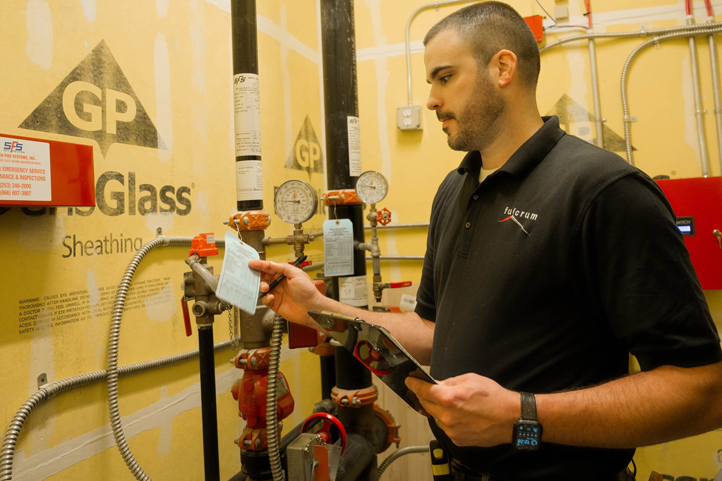 a man inspecting labels on pipes